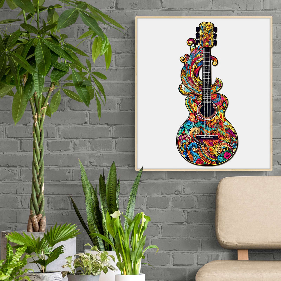 Colorful guitar artwork with vibrant patterns hanging in a modern room with plants and a cozy chair.