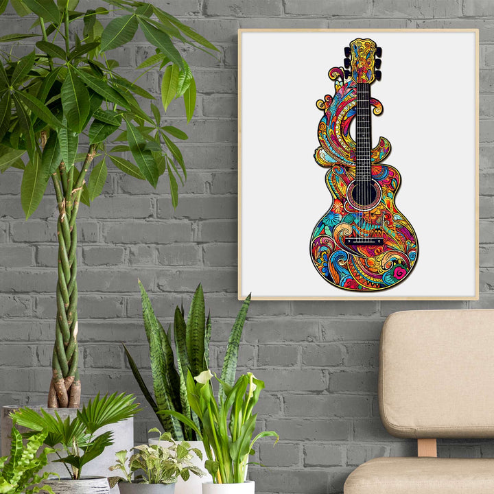 Colorful guitar artwork with vibrant patterns hanging in a modern room with plants and a cozy chair.