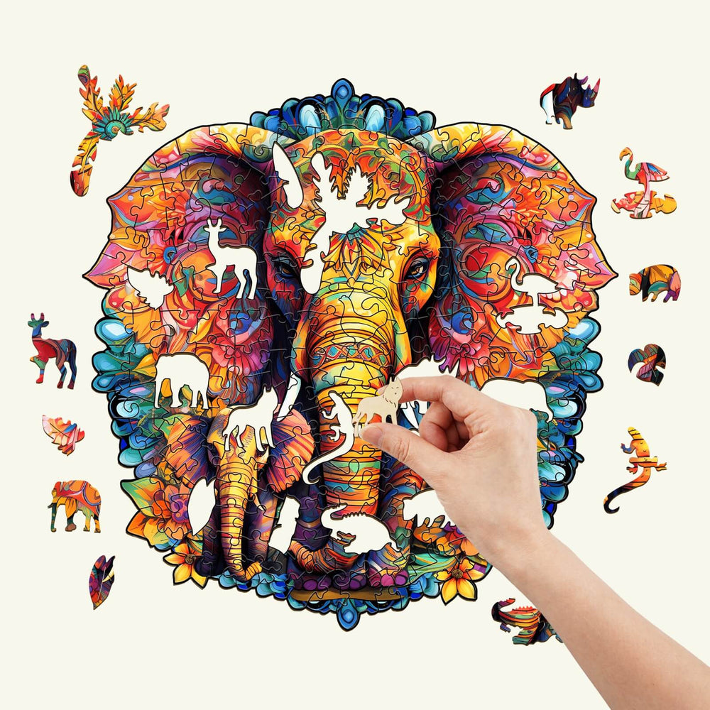 Hand placing a unique piece into the vibrant Mandala elephant wooden jigsaw puzzle showcasing lively animal designs.