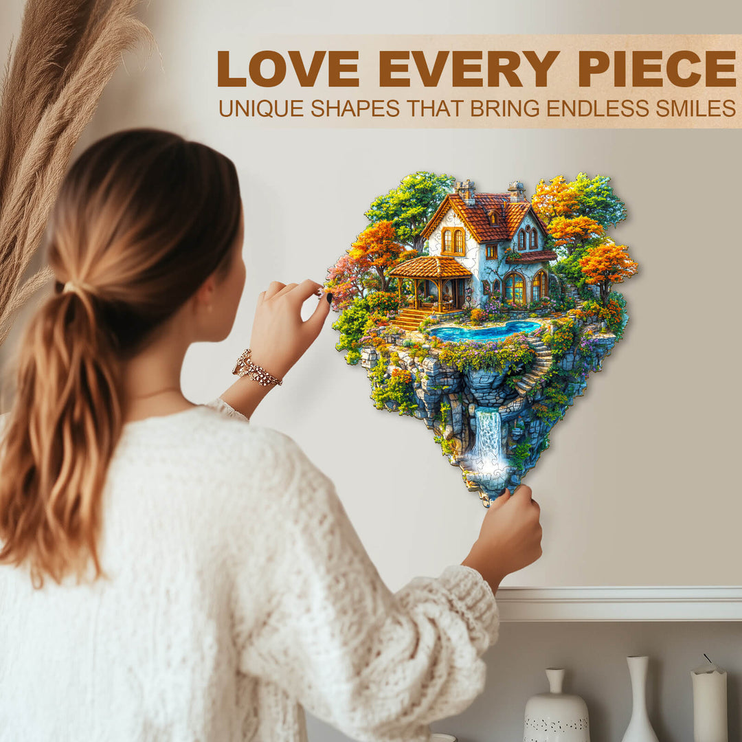 Person assembling Floating Haven Wooden Jigsaw Puzzle, showcasing unique shapes and vibrant cottage scene.